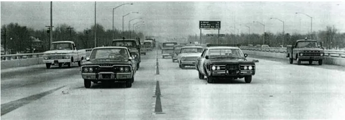 A black and white photo of cars driving on a freeway.