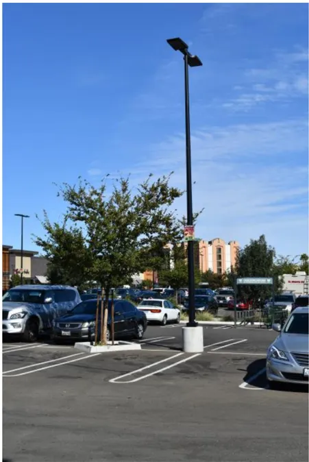 A photo of a light pole in a parking lot.