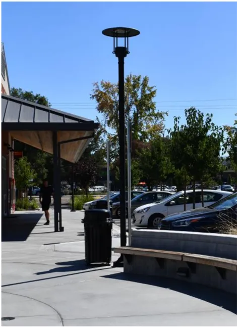 A photo of a light pole in a walkable area.