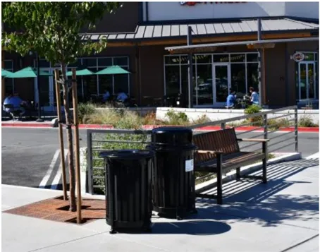A photo of site furnishings including garbage cans and a bench.