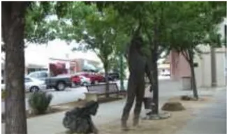 A photo of a statue in a landscape planter.