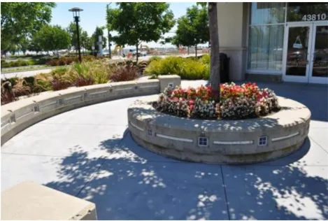 A photo of a circular planter with a walking path around it.
