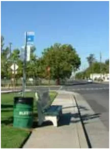 A photo of a bus stop and a trash can.