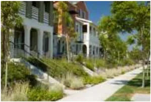 A photo of townhomes with a sidewalk in front.