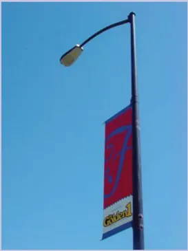 A photo of a light pole with a blade sign attached.