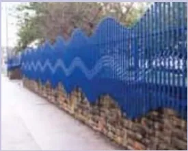 A photo of a wall with decorative blue fencing on top.