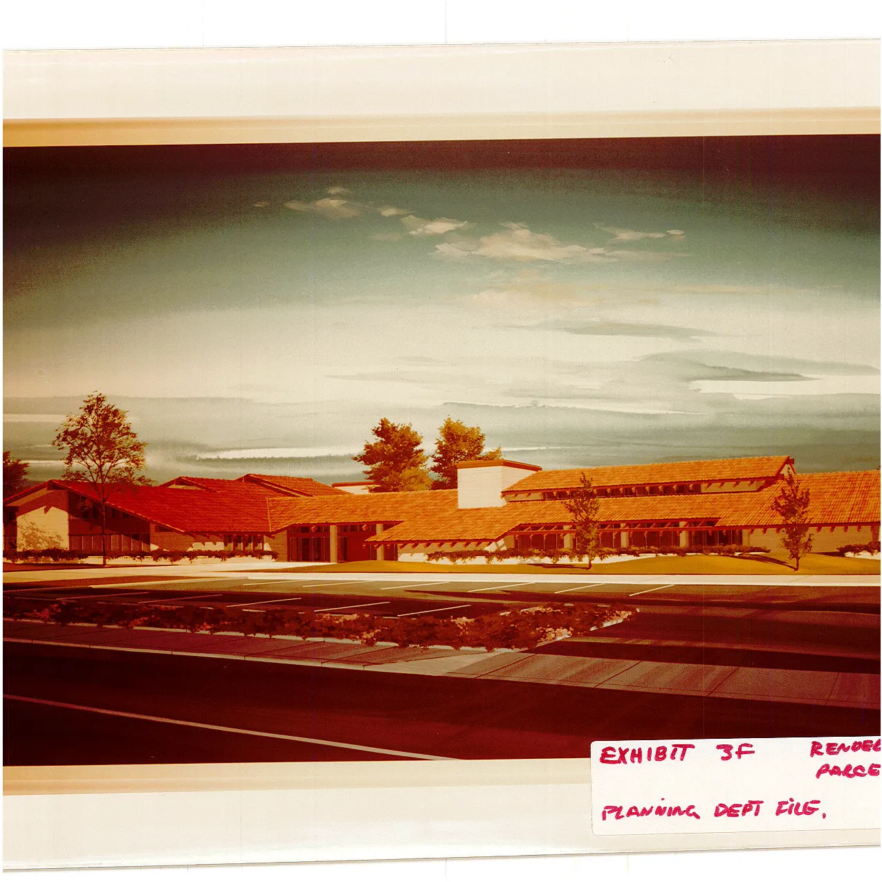 Color rendering of the proposed single-story, Mission-style office building with red clay tile roofs and connected gabled wings, fronted by landscaping and a striped parking lot.