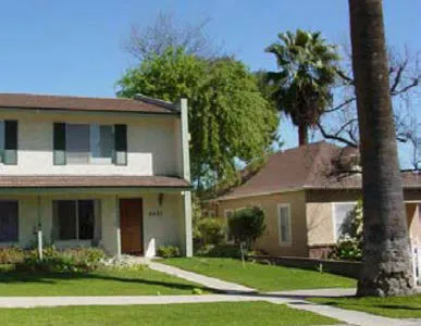 A two story house with a zero lot line adjacent to a single-family detacehd house with a setback.