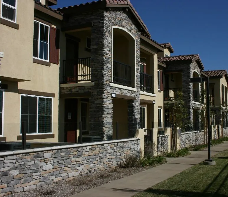 Multifamily building with offset wall planes facing common area