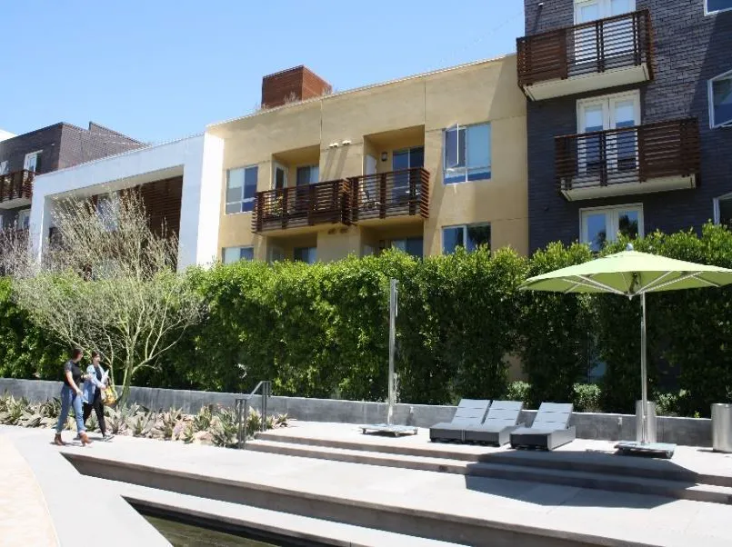 Articulate multifamily buildings with windows and balconies facing toward common seating area