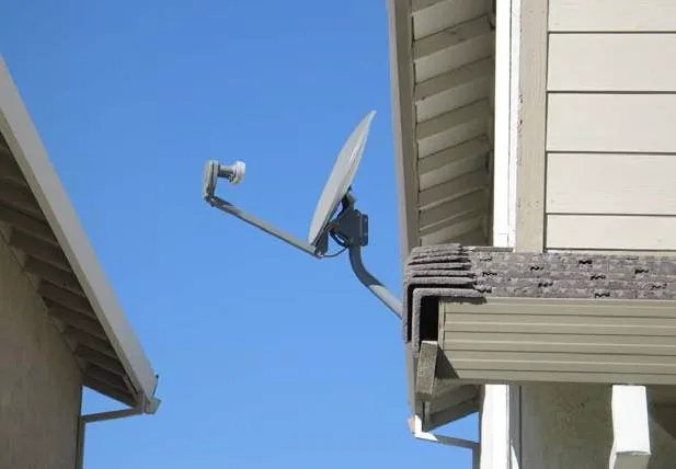 TV satellite dish placed on the side of the building for concealment.