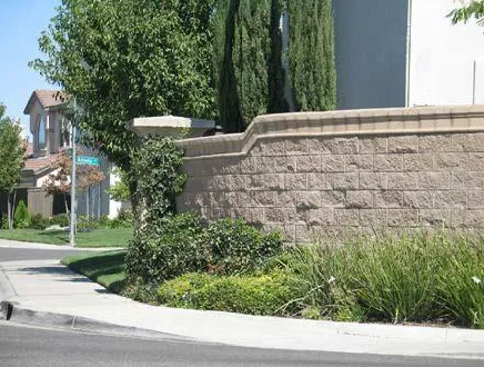 A CMU wall serving as a fence on a corner property.