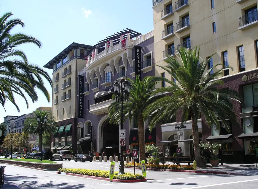 Storefront of mixed used building including planting strips and pedestrian scaled lighting.