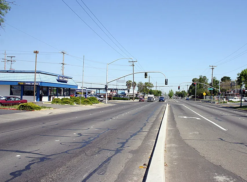 Commercial corridor with no planting strips and little to no pedestrian features.