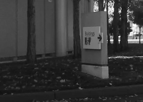 A masonry wall behind landscaping, shown as the desirable option