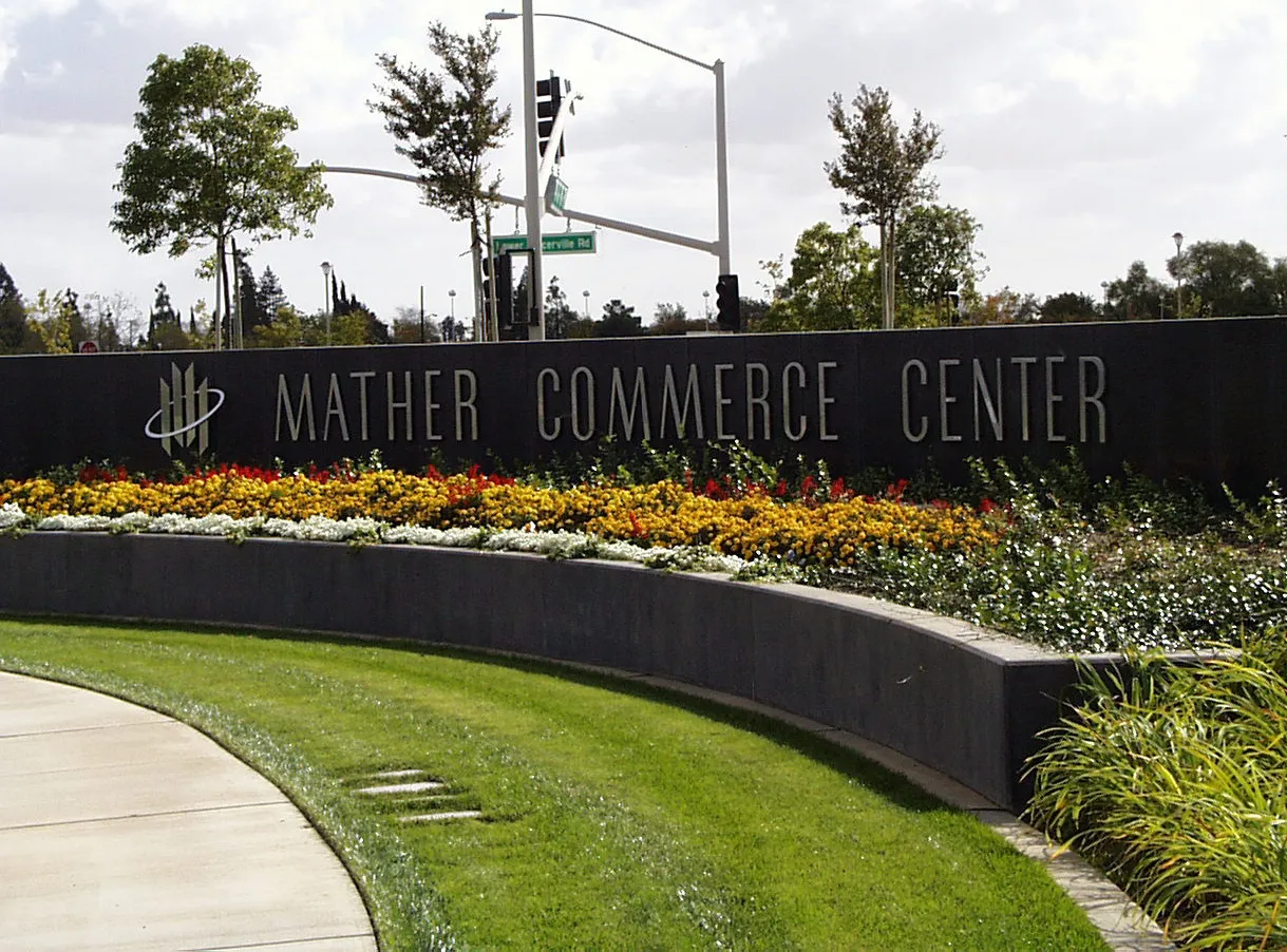 Monument sign of the "Mather Commerce Center", with lots surrounding of landscaping.