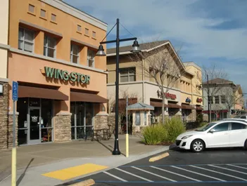 Multi-tenant commercial center with large walkable areas at the storefront.