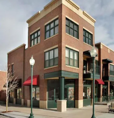 A vertical mixed used building with commercial on the ground floor and residential on top.