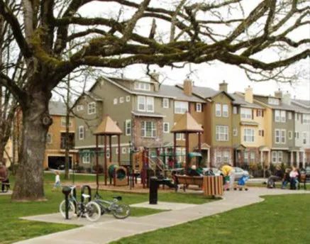 Residential townhome buildings next to a park.