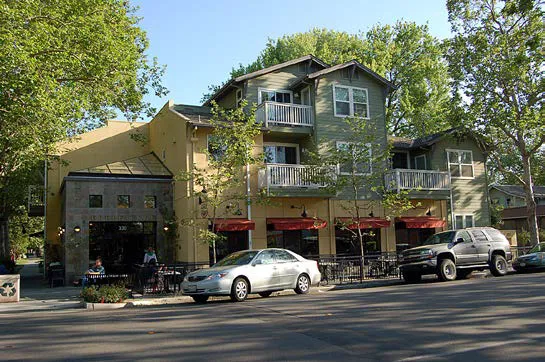 A vertical mixed use building with apartments over a restaurant.