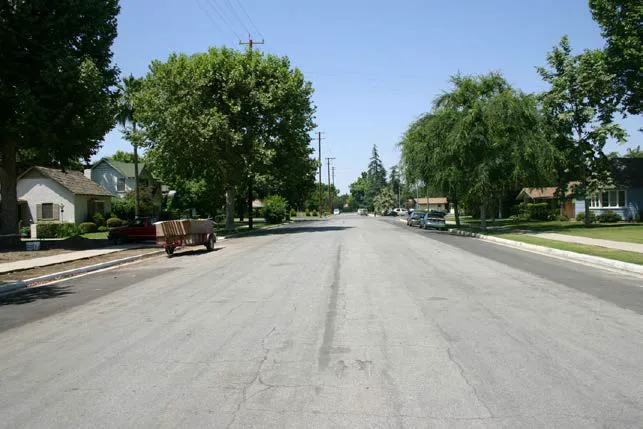 A wide road in a residential neighborhood.