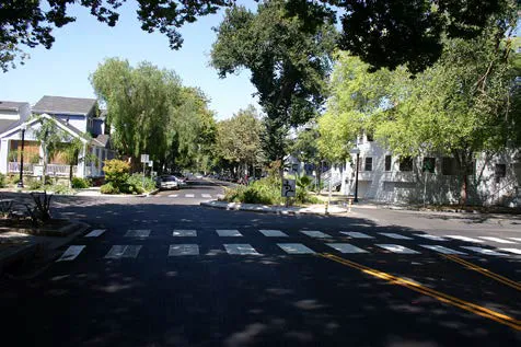 A cross walk with dashed lines around a cul-de-sac in a residential neighborhood.