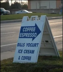 An white A-form style sign with an arrow pointing right