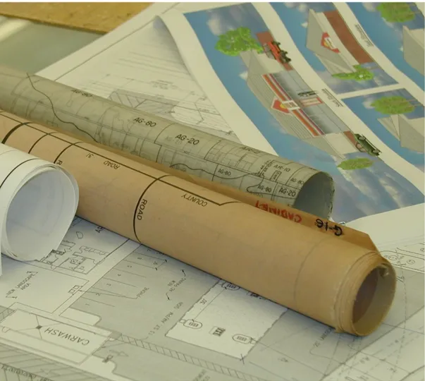 Rolled-up maps and diagrams sitting on a desk.