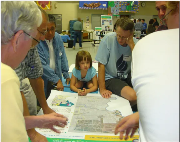Six adults and a child looking at a map.