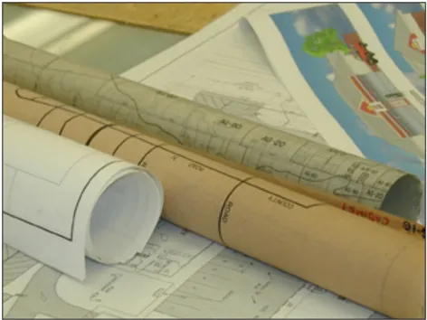 Rolled-up maps and diagrams sitting on a desk.