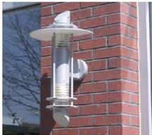 White cylindrical outdoor light fixture mounted on a brick wall.