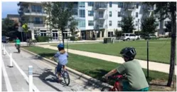Three people riding their bike on a Class II bike lane.