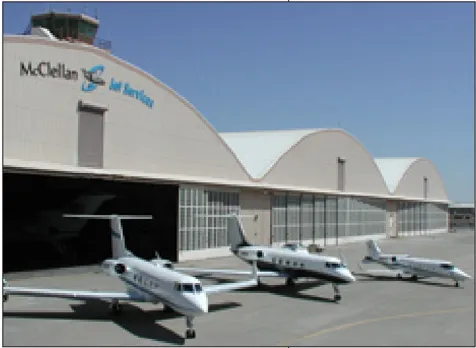 Three airplanes in front of a hangar with a sign that says "McClellan Jet Services."