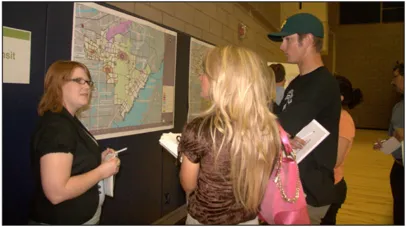 A woman discussing a map with two other people.
