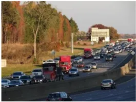 Four lane freeway with heavy vehicular traffic.